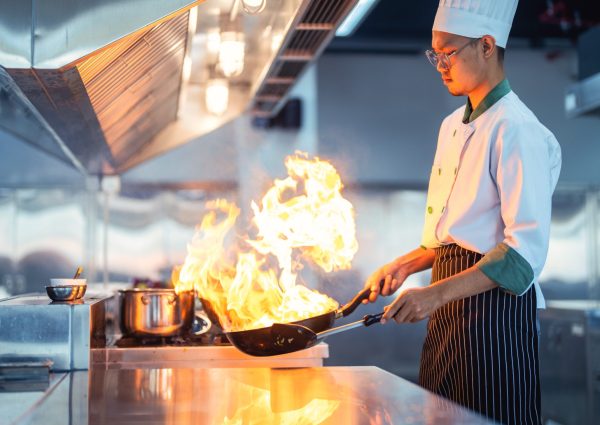 Chef,In,Restaurant,Kitchen,At,Stove,And,Pan,Cooking,Flambe